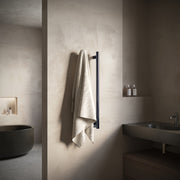 ICO Como electric hardwired towel warmer in Gunmetal, styled in a bathroom setting